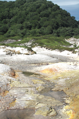 硫黄のせいか黄ばんだ岩場